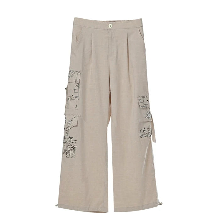 Beige wide-leg pants with patch designs on a white background
