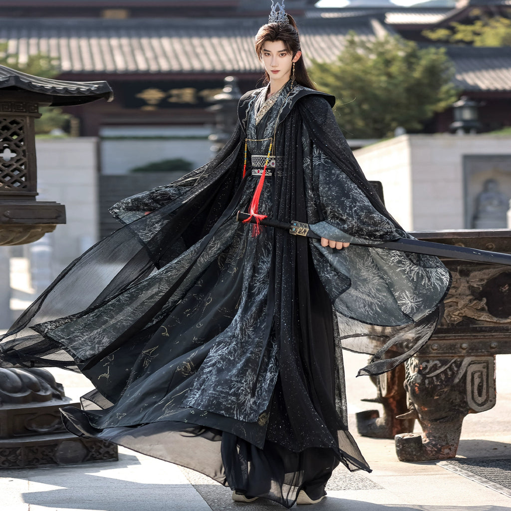 Person in traditional dark-colored robe with intricate patterns standing in a historical setting.